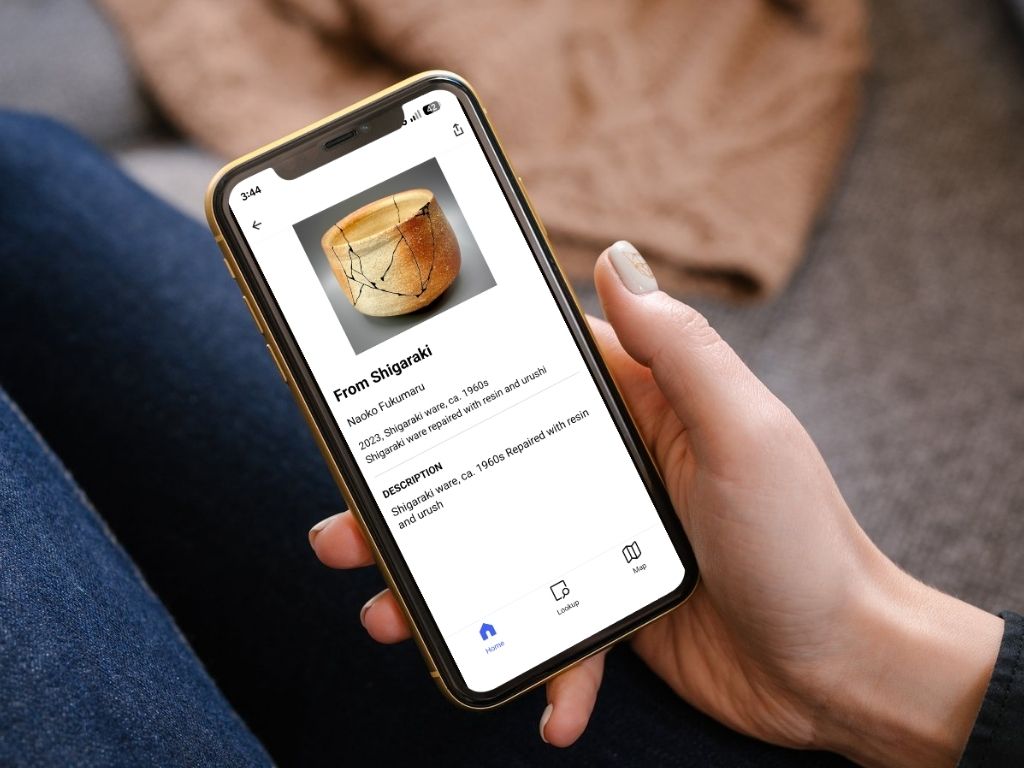 Photo of a woman holding a phone using Bloomberg Connects