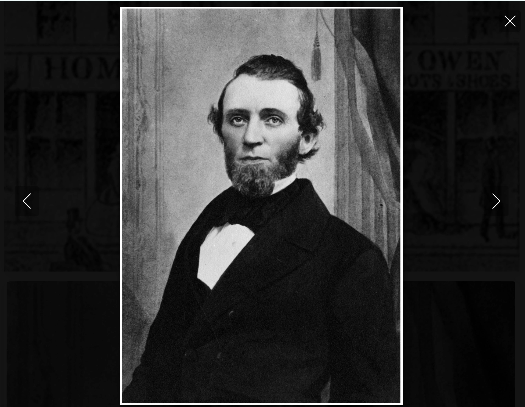 A strapping young man with beard and suit poses for a portrait.